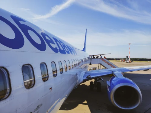 A Boeing 737 is seen at the gate with passengers boarding.