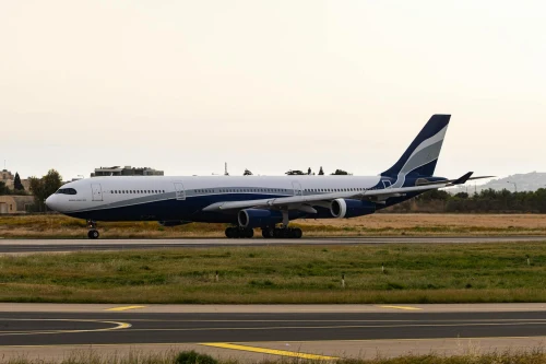 A Cyprus Airways Airbus A340 is taxiing on the runway.