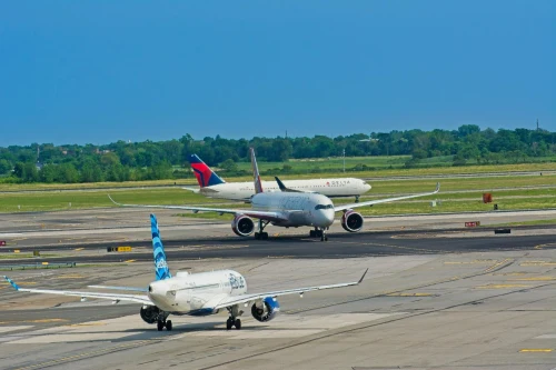 Delta Airlines (DL) aircraft on the apron under clear skies.