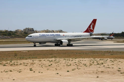 A Turkish Airlines Airbus A330 is taxiing on the runway.