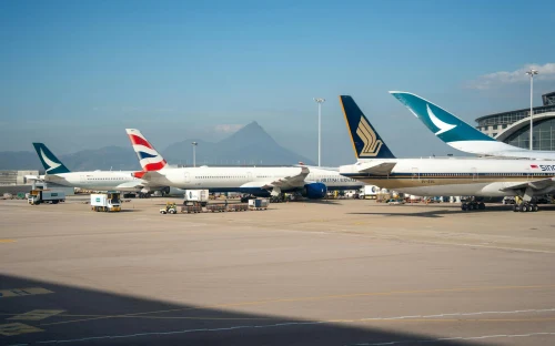 A South Asia Airlines Boeing 777 parked at the gate alongside other international carriers.