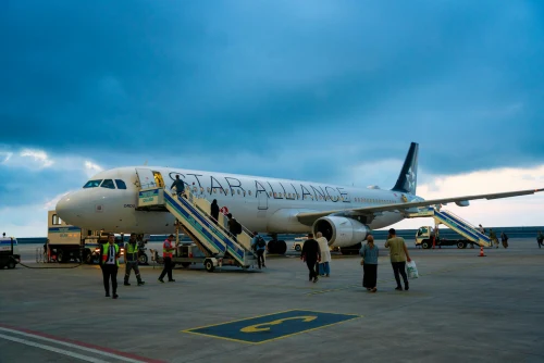 A Star Peru Airbus A321 is parked at the apron with passengers boarding via stairs.