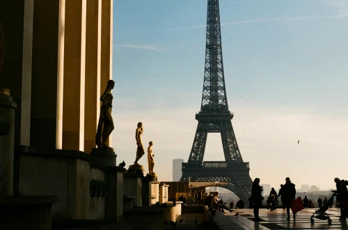 Tourists and statues at golden hour with the Eiffel Tower in the background, Paris