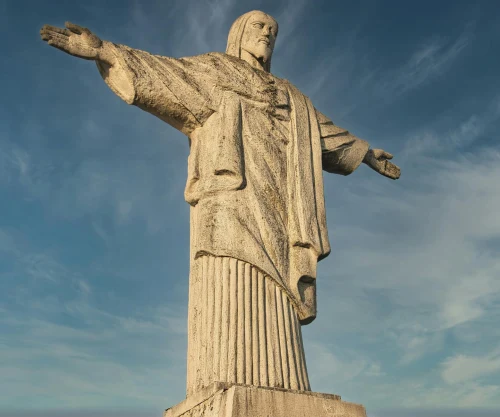 Low angle view of Christ the Redeemer statue in Rio de Janeiro against blue skies