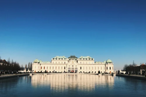 Stunning view of Belvedere Palace with reflection in Vienna, Austria under a clear blue sky