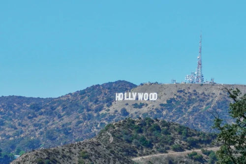 View of the iconic Hollywood Sign on the hills of Los Angeles under a clear blue sky