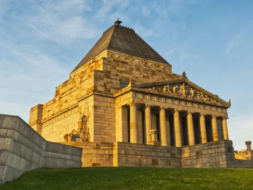 Majestic view of the Shrine of Remembrance during golden hour in Melbourne. Iconic war memorial against a blue sky