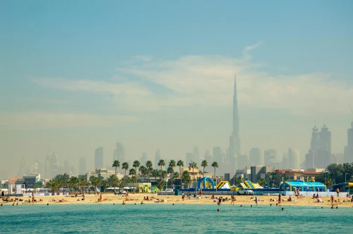 Tourists enjoying a sunny day at Dubai beach with Burj Khalifa and skyline in the background