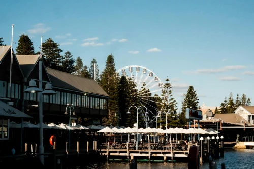 A captivating photo of Fremantle's waterfront with a Ferris wheel and modern architecture under a clear blue sky