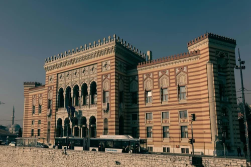 The Vijecnica Sarajevo, an iconic architectural landmark featuring intricate designs and stripes under a clear sky