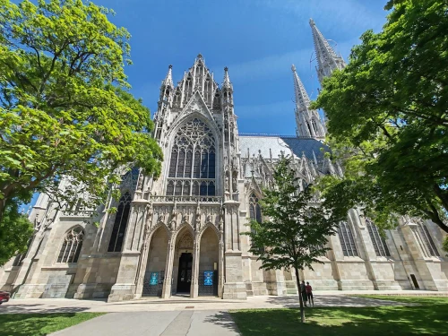 A stunning Gothic cathedral surrounded by lush trees on a sunny day