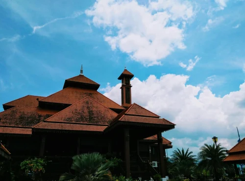 A beautifully crafted traditional building with a striking roof design set against a picturesque blue sky