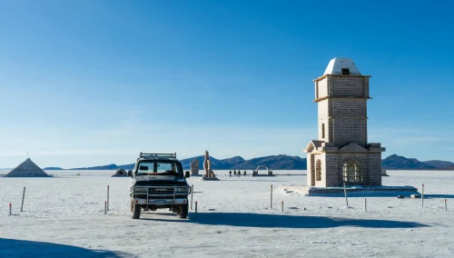 Explore Toyota SUV standing majestically on Bolivia's iconic Salar de Uyuni salt flats under a clear blue sky