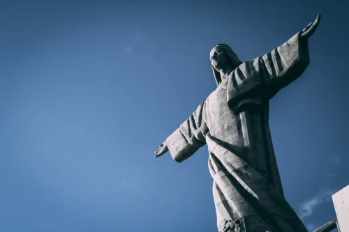 Iconic Christ the Redeemer statue with arms outstretched against a clear blue sky