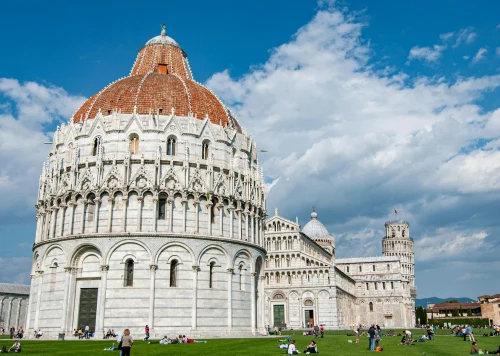 View of Pisa's Baptistery and iconic Leaning Tower against a blue sky