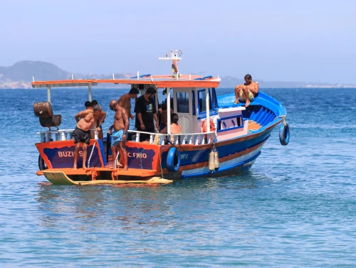 Vibrant fishing boat with passengers enjoying a sunny day on clear Brazilian waters