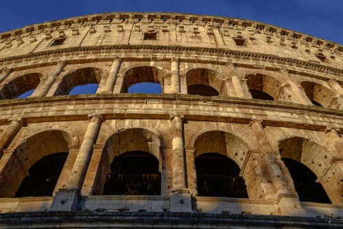 Close-up view of the Colosseum in Rome during sunset, showcasing its ancient architecture