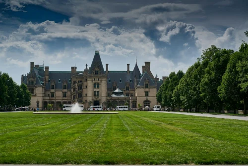 Stunning view of Biltmore Estate in Asheville with vibrant gardens and clear sky, showcasing architectural grandeur