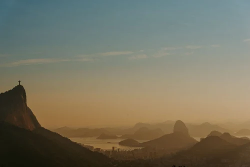 sunset view of Rio de Janeiro with the Christ the Redeemer statue and iconic Sugarloaf Mountain