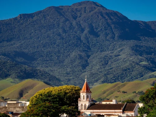 Scenic view of Cruzeiro with lush mountains and iconic church tower against a clear sky