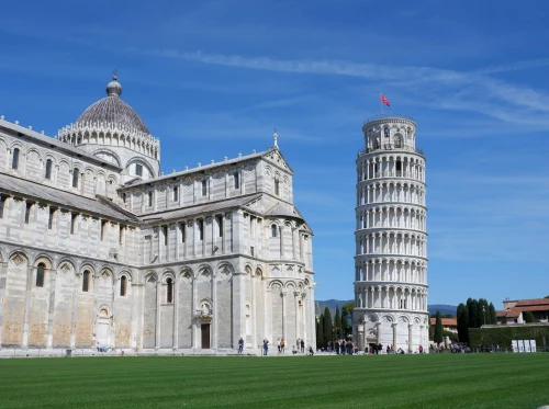 The iconic Leaning Tower of Pisa and Cathedral under a bright blue sky