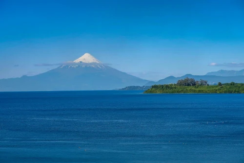 view of Osorno Volcano towering over Lake Llanquihue under a clear blue sky