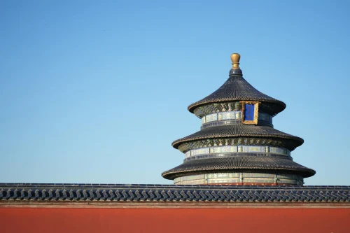 The iconic pagoda of the Temple of Heaven in Beijing, China stands against a clear, blue sky