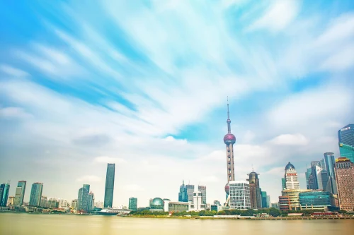 Vibrant Shanghai skyline featuring the iconic Oriental Pearl Tower under a bright blue sky