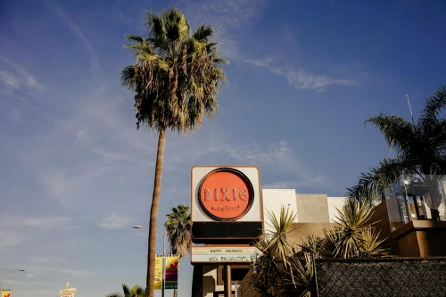 Sunny day showcasing iconic Dixie Hollywood signage with palm trees and clear blue sky