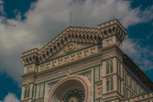 Close-up of Florence Cathedral's ornate facade with intricate designs under a blue sky