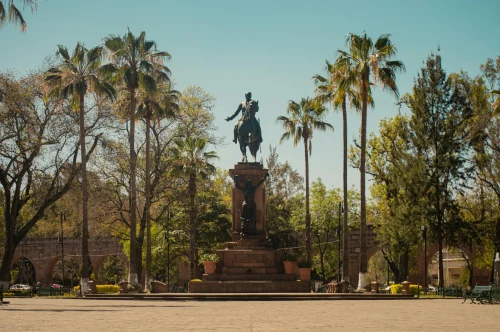 Sunny day at Monument to Morelos with palm trees and park in Morelia, Mexico