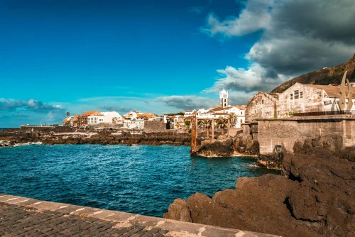 Beautiful coastal town with rocky shoreline under a bright blue sky