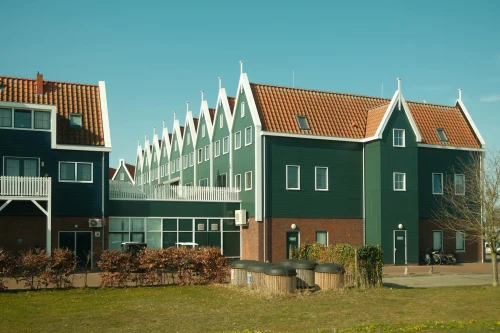 Iconic Dutch houses with green facades in Volendam, Netherlands, on a sunny day