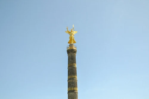 The iconic Berlin Victory Column under a clear blue sky, showcasing its golden statue