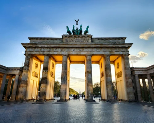 The iconic Brandenburg Gate in Berlin, captured during sunset with glowing light