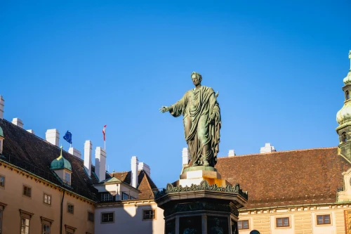 A captivating view of a statue at the Hofburg Palace in Vienna with a clear blue sky
