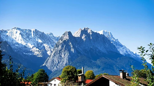 Sunny view of the Bavarian Alps in Garmisch-Partenkirchen with snow-capped peaks and houses