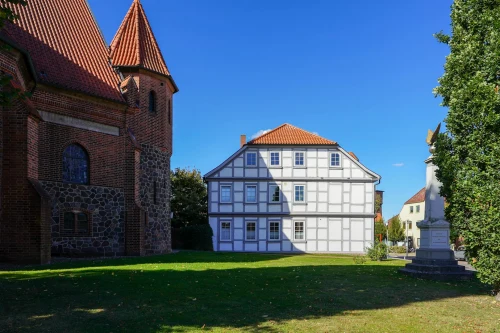 Scenic view of timbered house and historic church in Dahlenburg, Germany, under a clear blue sky
