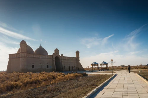 A historic mausoleum with domes under a clear blue sky, showcasing rich architecture