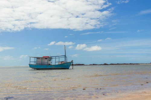 Serene view of a fishing boat on Morro de São Paulo beach in Bahia, Brazil under a clear blue sky