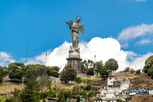 The majestic Panecillo angel statue stands over Quito, Ecuador with a clear blue sky backdrop