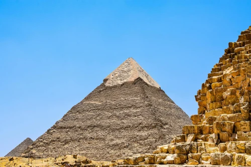Iconic pyramids under a clear blue sky in Giza, capturing ancient history