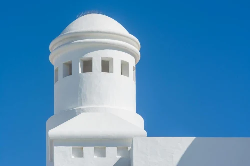Bright white tower with traditional architecture under a clear blue sky, Lanzarote, Spain