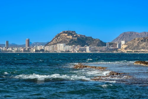 Picturesque view of Alicante's coastline with the iconic Santa Bárbara Castle on a sunny day