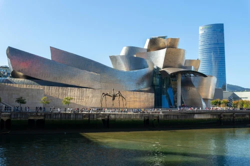 The iconic Guggenheim Museum in Bilbao by the river under a clear blue sky