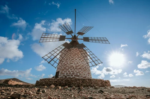A traditional stone windmill under a bright sunny sky in Fuerteventura, Spain