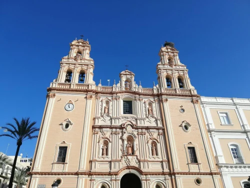 View of the beautiful ornate facade of Huelva Cathedral under a clear blue sky, an iconic landmark in Spain