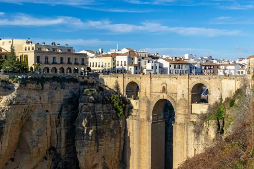 view of the iconic Puente Nuevo bridge spanning the gorge in Ronda, Spain on a sunny day