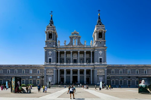 View of Almudena Cathedral with tourists enjoying a sunny day in Madrid Spain