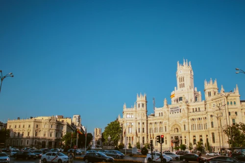 View of Madrid's famous Cibeles Palace on a sunny day with bustling traffic in the foreground